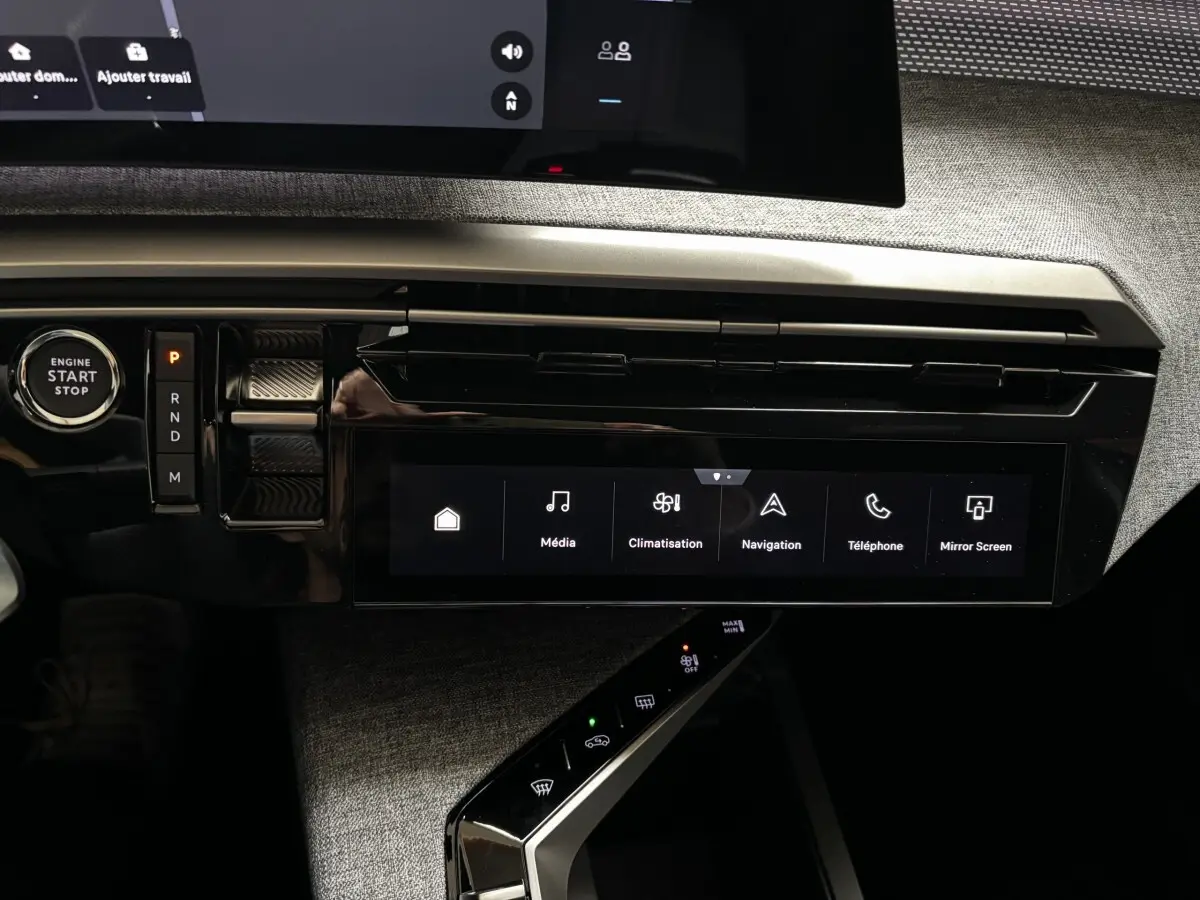 Vue rapprochée de la console centrale noire brillante du Peugeot 3008 1.2 Hybrid 145 GT avec écran tactile et bouton start/stop.