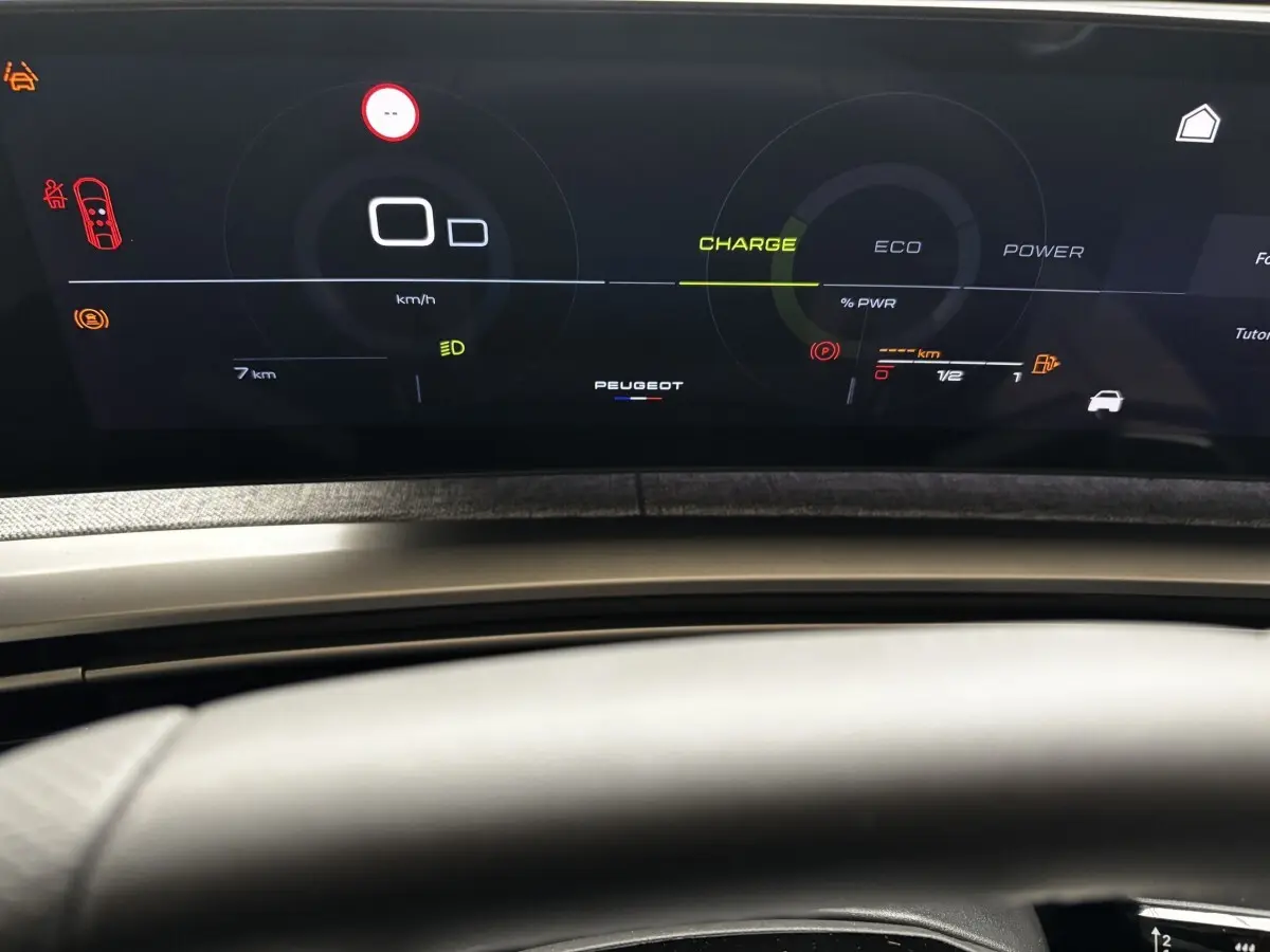 Tableau de bord numérique du Peugeot 3008 hybride 2025, affichage multifonctions avec indicateurs de charge et vitesse.