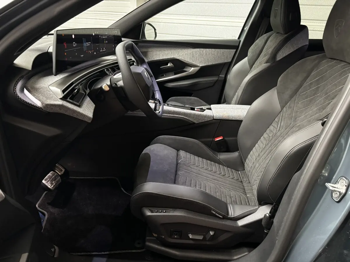 Vue intérieure côté conducteur du Peugeot 3008 1.2 Hybrid 145 GT 2025, sièges cuir et alcantara gris, écran tactile large.