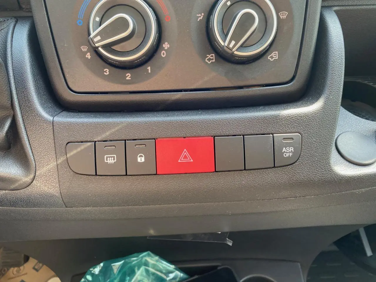 Gros plan sur la console centrale du Citroën Jumper 2023, montrant les commandes de climatisation et boutons de sécurité.