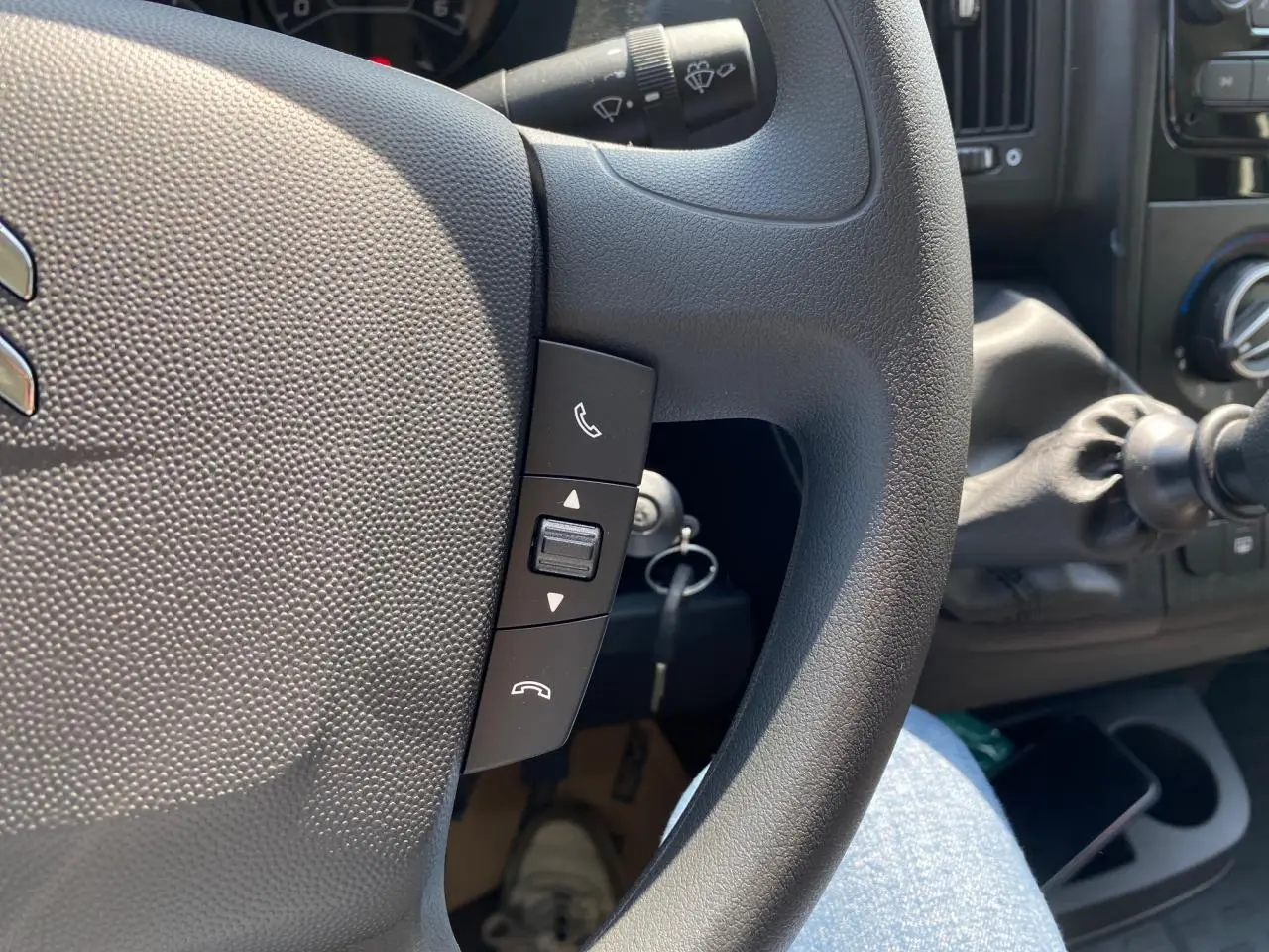 Gros plan sur le volant noir du Citroën Jumper 2023 avec commandes Bluetooth et levier de vitesse manuel visible.