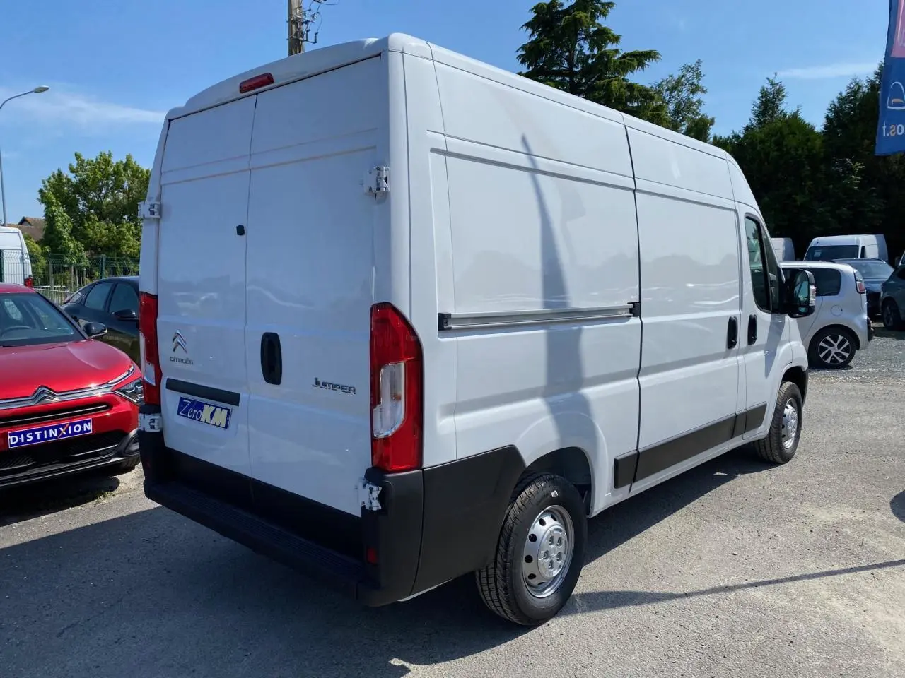 Vue 3/4 arrière droite d’un Citroën Jumper blanc 2023 avec portes arrière tôlées et jantes acier.