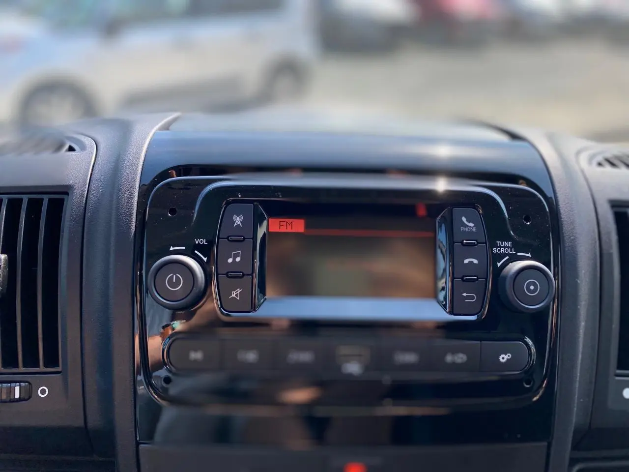 Tableau de bord du Citroën Jumper 2023 avec écran radio FM et commandes audio en gros plan.