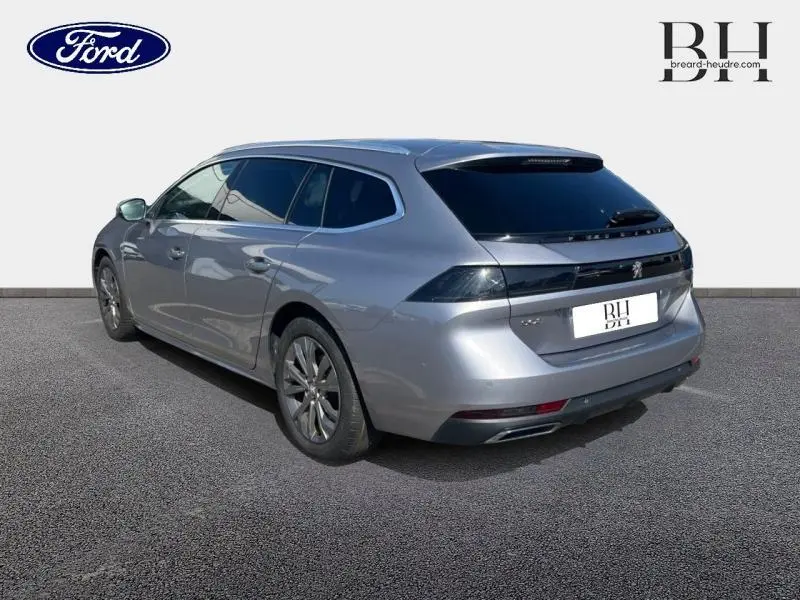 Peugeot 508 SW gris Artense vue 3/4 arrière droit, break avec vitres arrière surteintées et jantes alu.