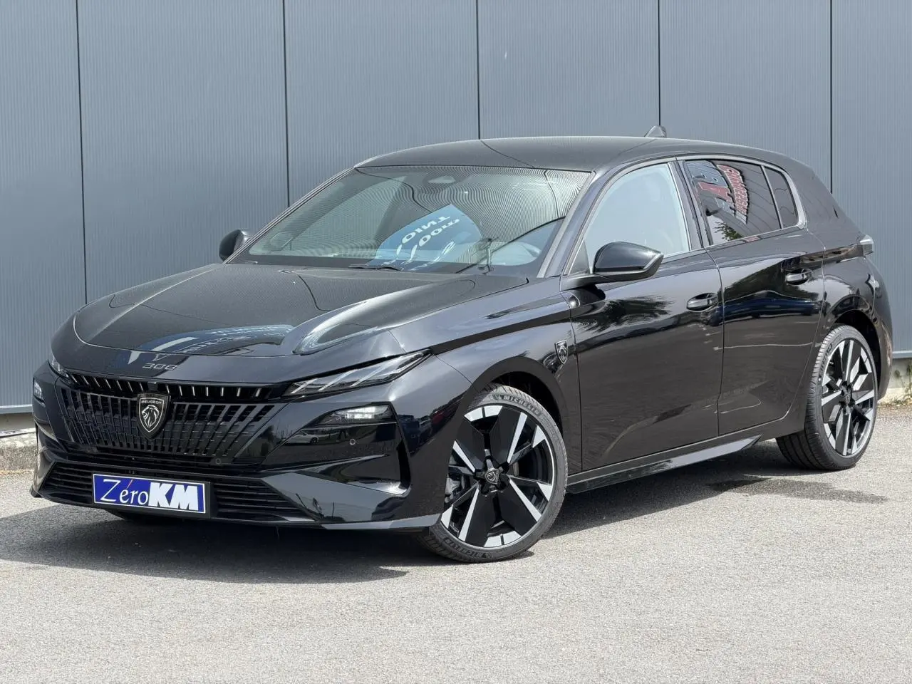 Peugeot 308 NV Hybrid 145 GT noir Perla, vue 3/4 avant droit, jantes alliage bi-tons et calandre distinctive.