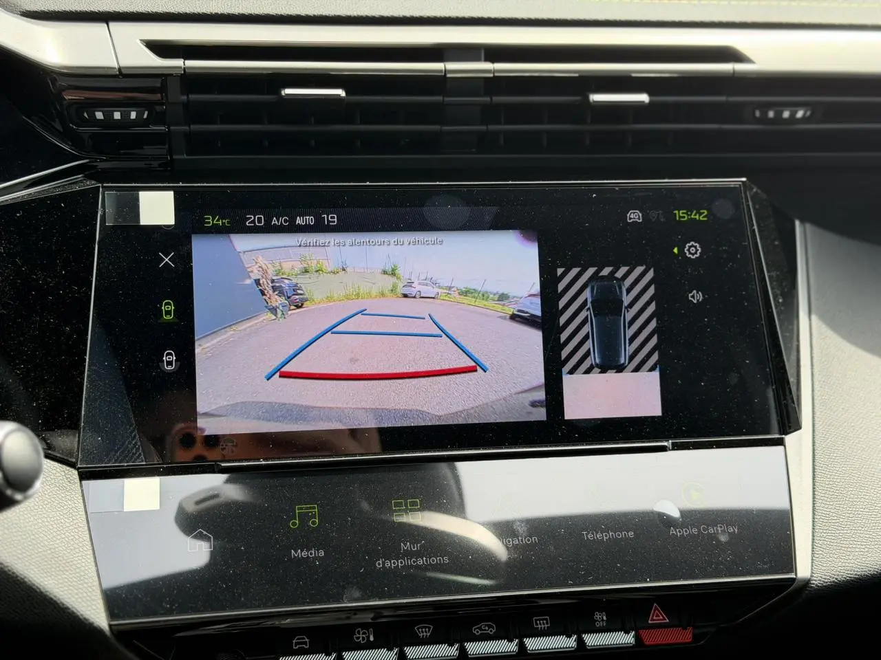 Écran tactile intérieur de la Peugeot 308 NV Hybrid 145 GT e-DSC6 montrant la caméra de recul et l’aide au stationnement.