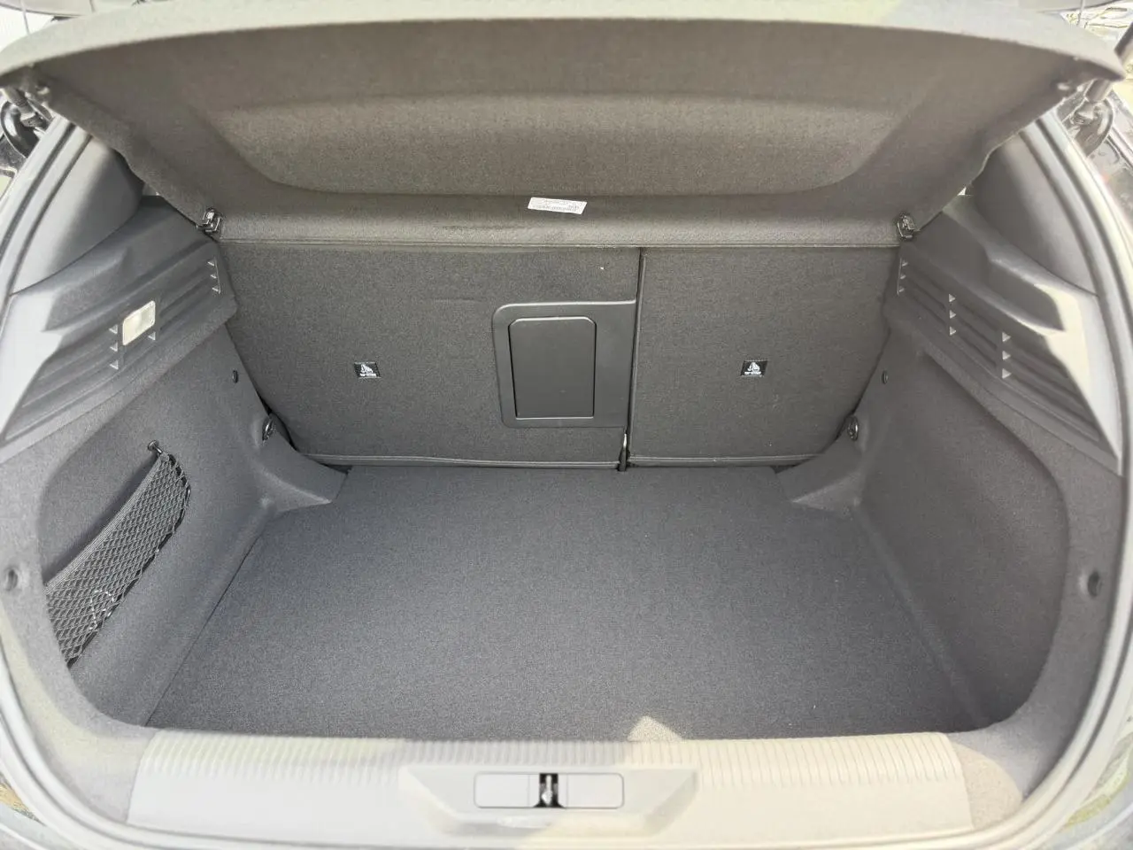 Coffre ouvert de la Peugeot 308 NV Hybrid 145 GT e-DSC6 noir Perla, montrant un espace de chargement propre et bien agencé.