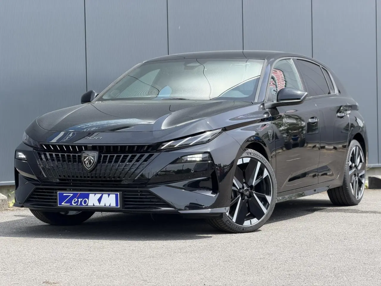 Peugeot 308 NV Hybrid 145 GT e-DSC6 noir Perla en 3/4 avant droit, avec jantes alliage bi-tons et calandre distinctive.