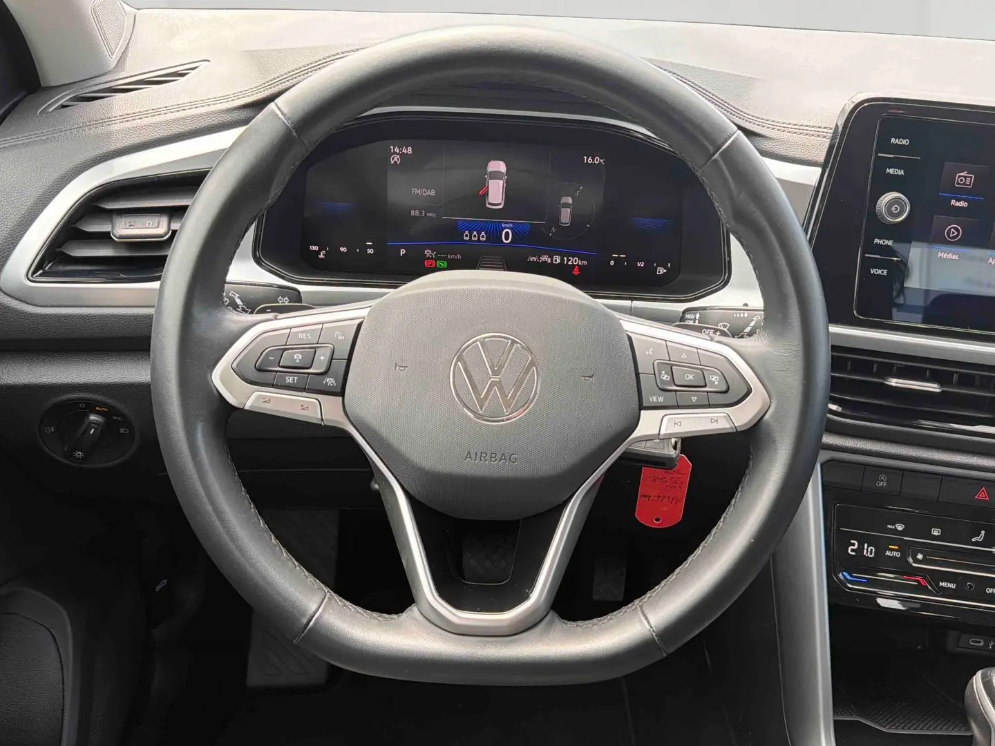 Vue intérieure centrée sur le volant cuir multifonctions du Volkswagen T-Roc 2025 avec tableau de bord digital et écran tactile.