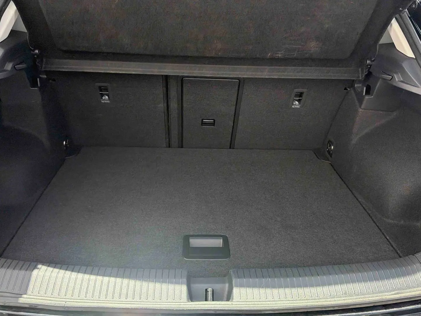Vue intérieure du coffre spacieux et propre du Volkswagen T-Roc noir, sans chargement visible.