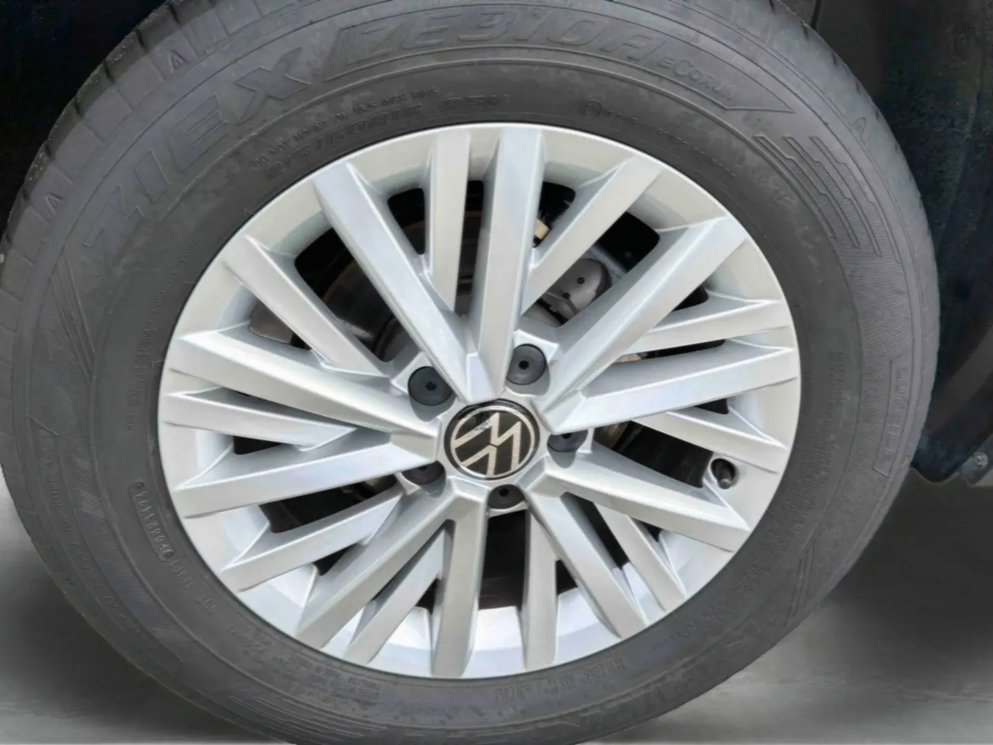 Gros plan sur la jante alliage 16'' Chester argentée du Volkswagen T-Roc noir, montrant le logo VW central.
