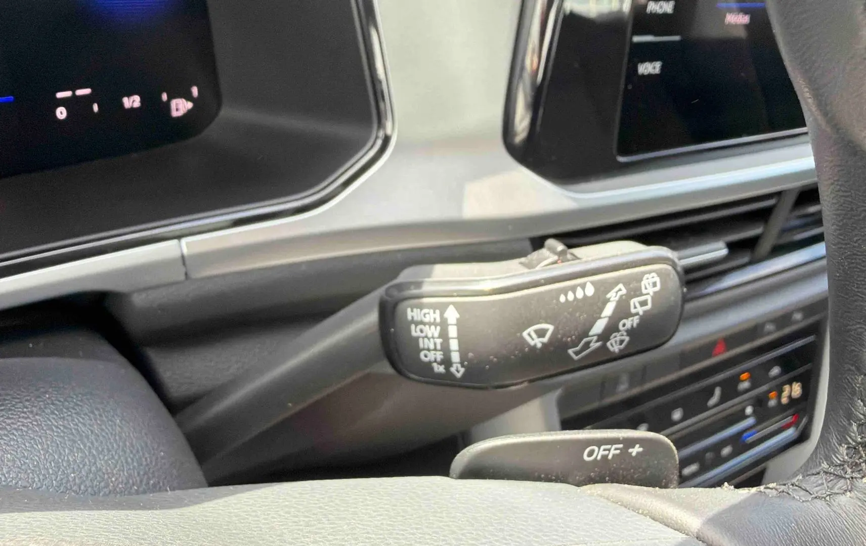 Gros plan sur la manette d’essuie-glace à gauche du volant dans l’habitacle du Volkswagen T-Roc noir 2025.