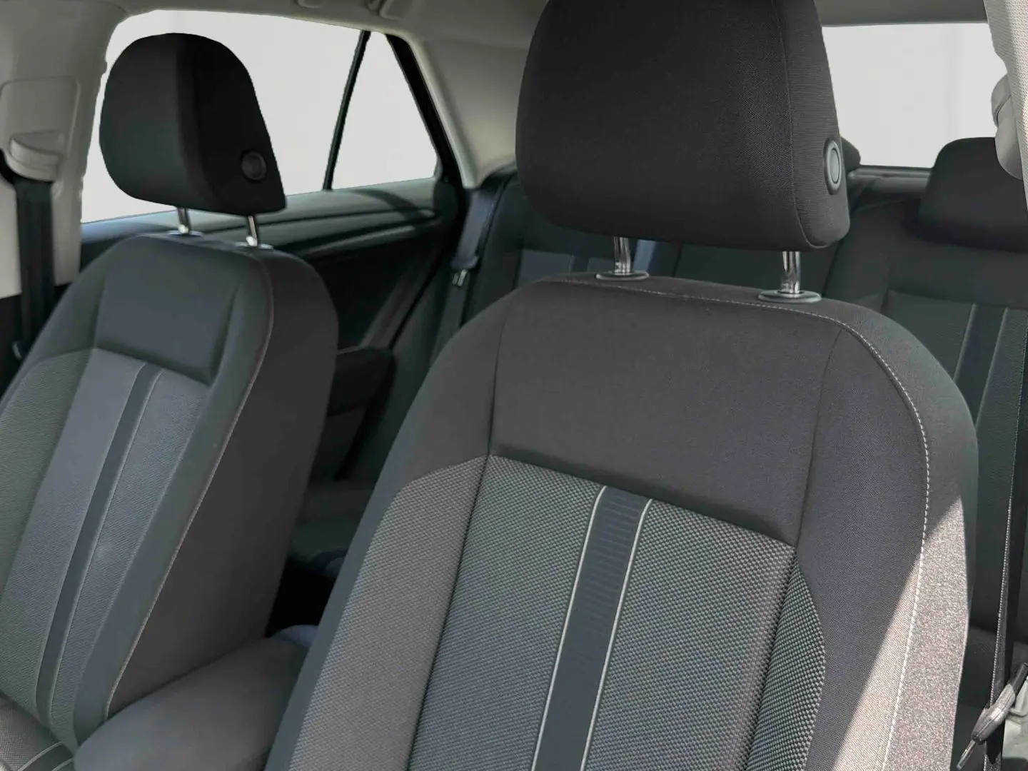 Gros plan sur les sièges avant en tissu gris et noir du Volkswagen T-Roc, intérieur sobre et moderne.