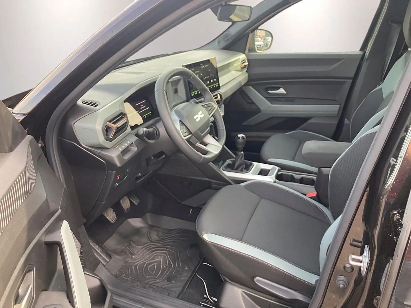 Vue intérieure côté conducteur du Dacia Bigster noir 2025, montrant le tableau de bord et les sièges avant.
