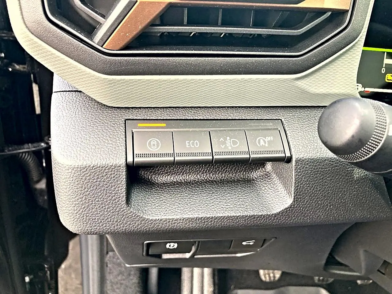 Gros plan sur les commandes de tableau de bord noir du Dacia Bigster 2025, avec bouton ECO et régulateur d’éclairage.
