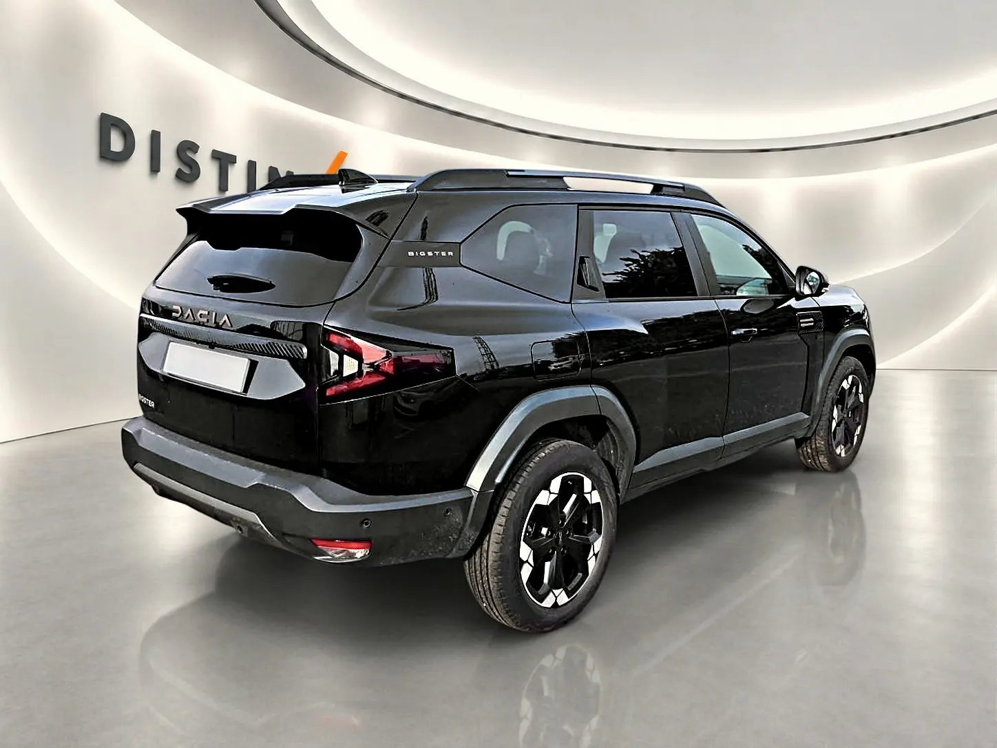 Vue 3/4 arrière droite d'un Dacia Bigster noir avec barres de toit et jantes alu distinctives.