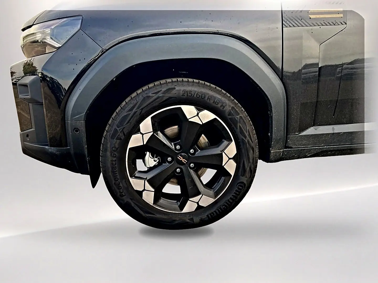 Gros plan sur la roue avant gauche noire du Dacia Bigster 2025 avec jante alu bicolore et passage de roue noir.