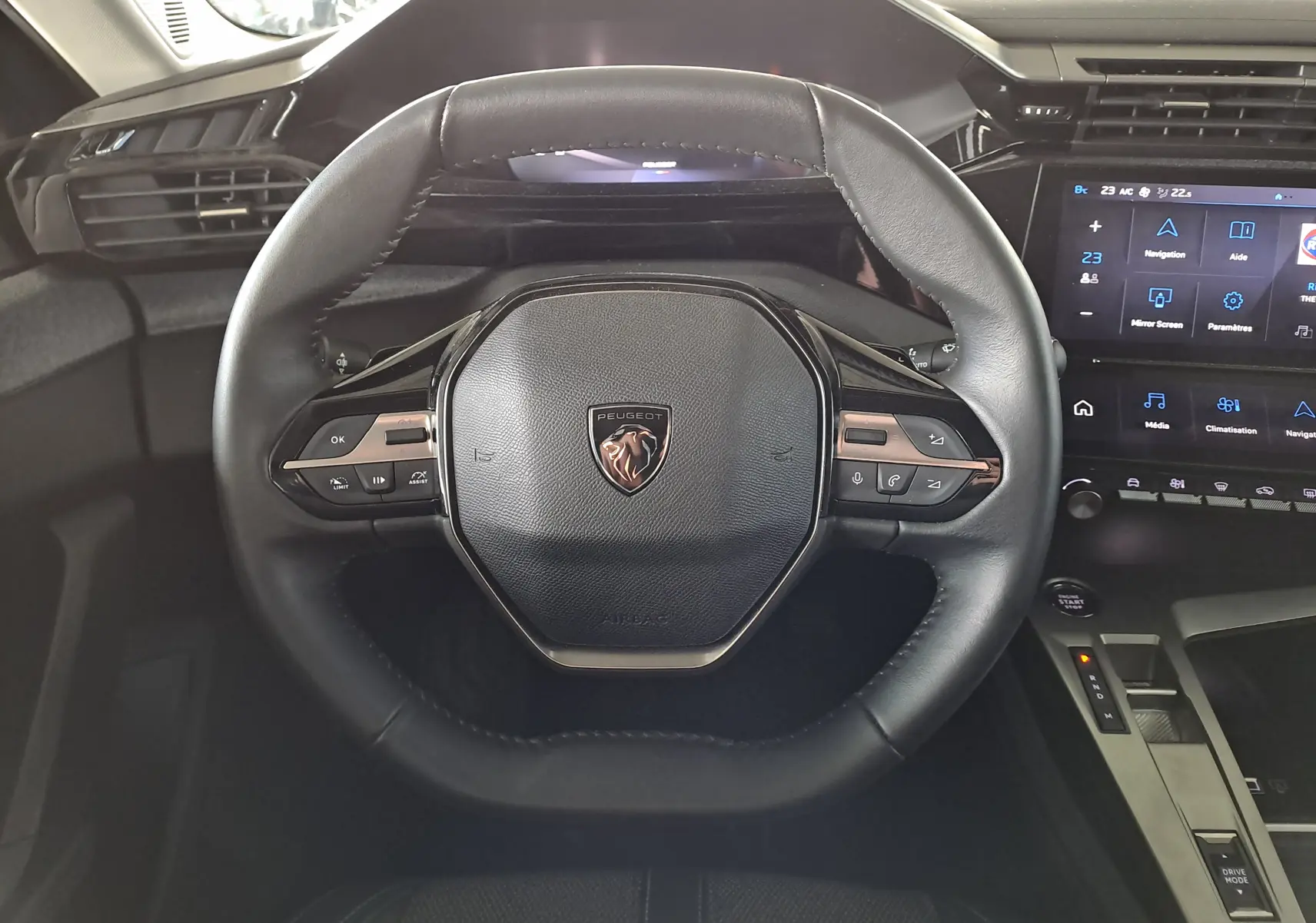 Vue rapprochée du volant cuir noir de la Peugeot 308 2024 avec commandes intégrées et tableau de bord digital.