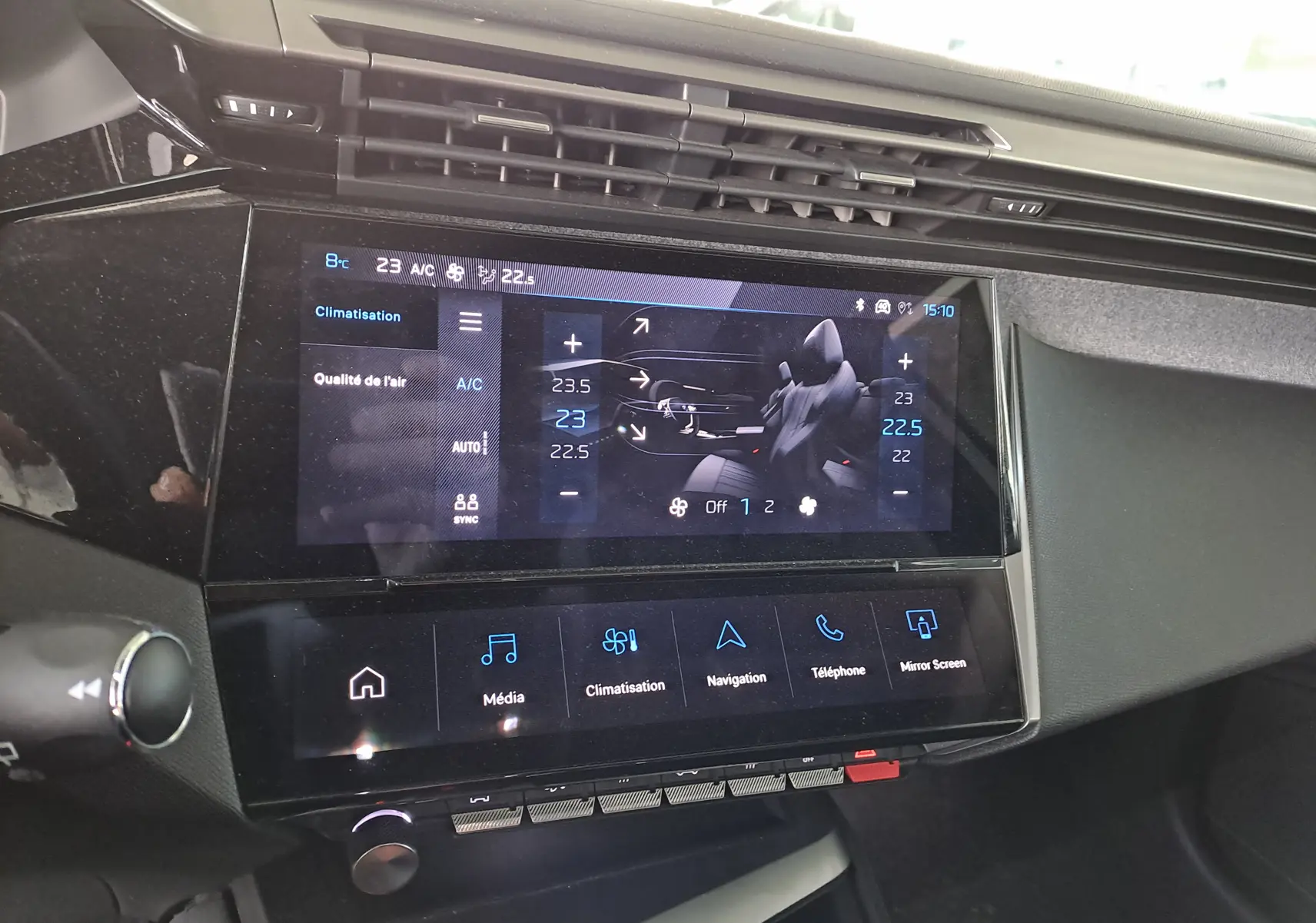 Écran tactile central du tableau de bord de la Peugeot 308 blanc Okenite 2024 affichant la climatisation et les options multimédia.