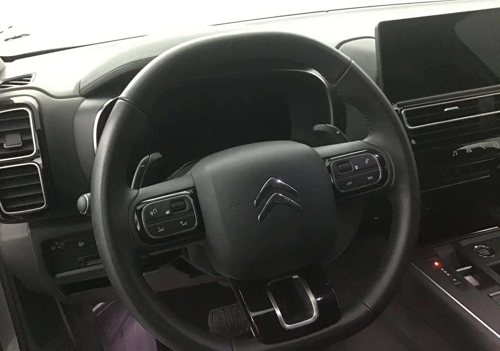 Volant en cuir noir de Citroën C5 Aircross 2024 avec commandes intégrées, tableau de bord et écran tactile visibles.