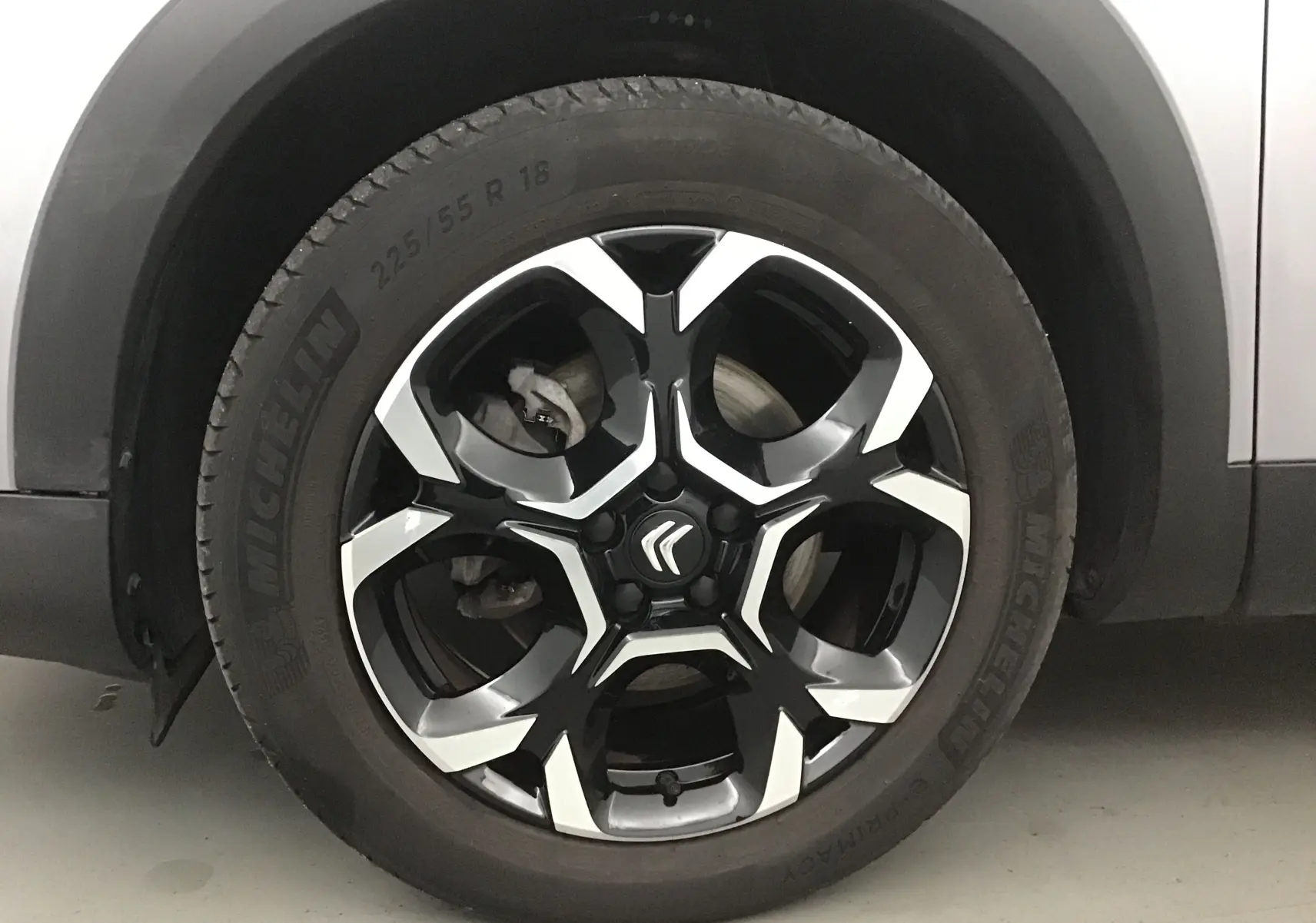 Gros plan sur la roue avant gauche du Citroën C5 Aircross 2024 gris Artense avec jante alliage noire et argentée.