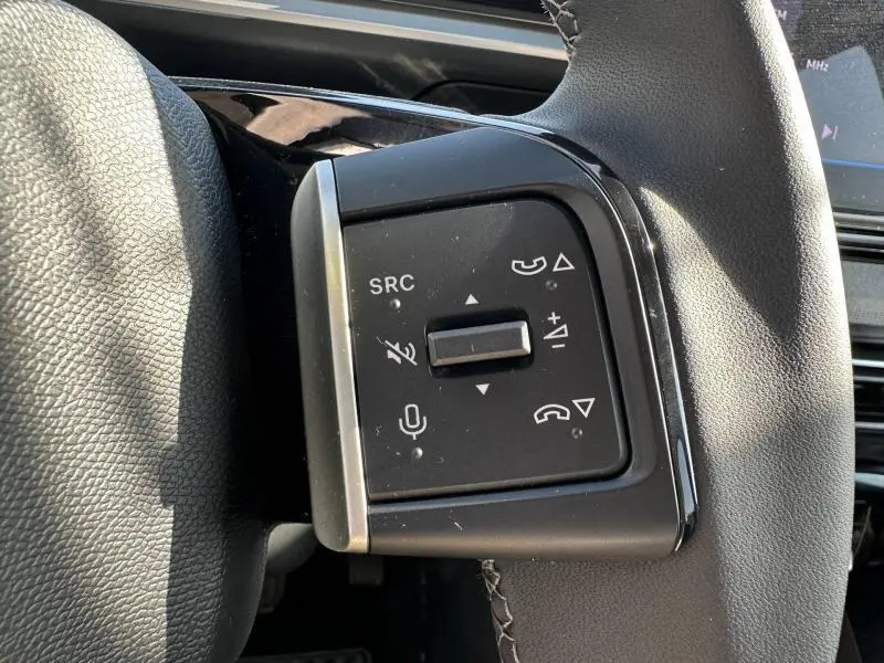 Gros plan sur les commandes audio et téléphone au volant noir de la Citroën C3 1.2 Turbo 2025 en Gris Mercury.