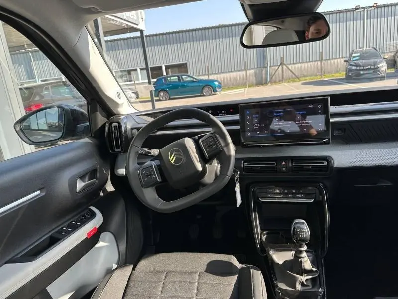 Vue intérieure avant de la Citroën C3 1.2 Turbo 100ch MAX 2025, volant multifonctions et écran tactile central.
