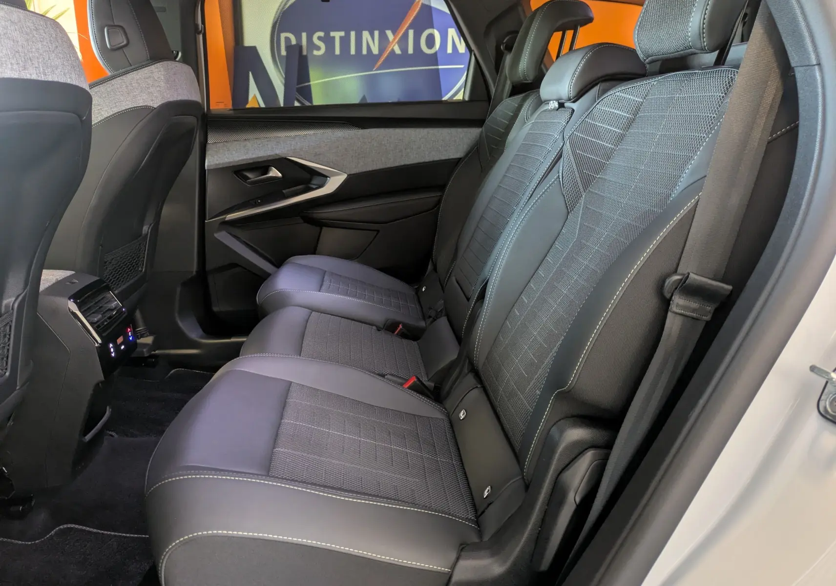 Vue latérale intérieure des sièges arrière du Peugeot 5008 Hybrid 145 e-DCS6 GT avec tissu gris et surpiqûres Iced Clay.