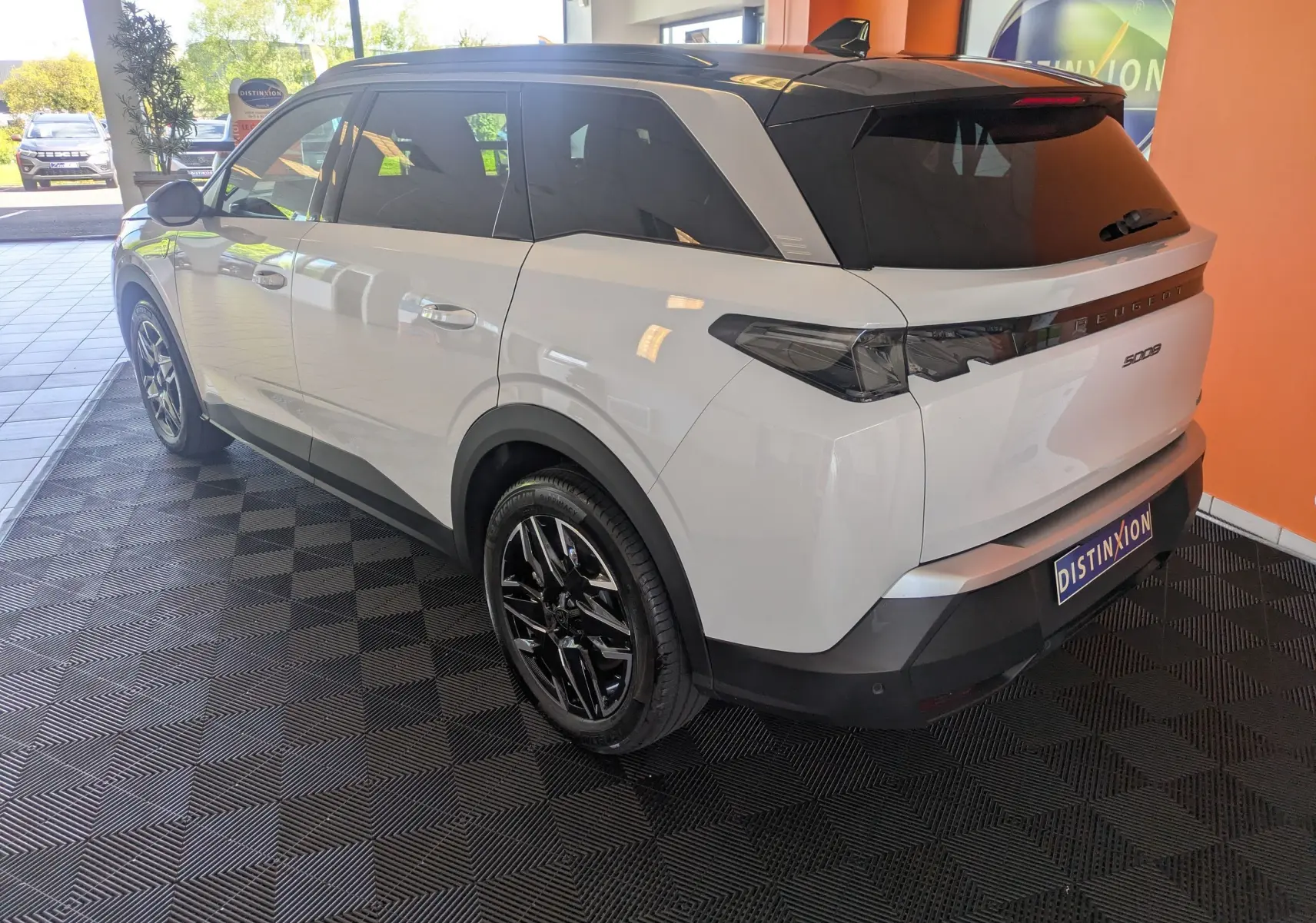 Peugeot 5008 Hybrid 145 GT blanc Okenite avec toit noir, vue 3/4 arrière droit, jantes alliage noires 19 pouces.