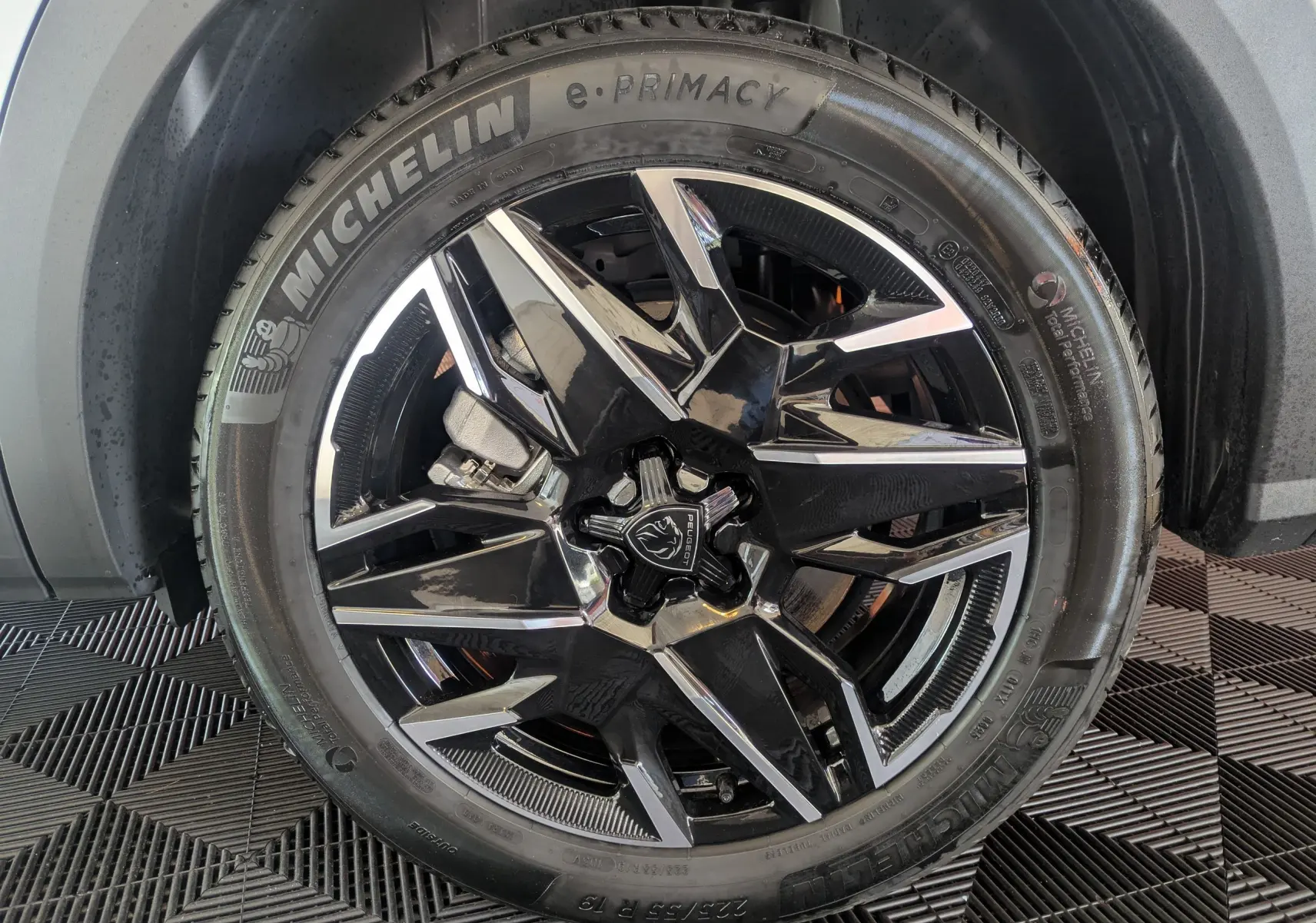 Gros plan sur la jante alliage 19’’ noire et polie du Peugeot 5008 Hybrid 145 e-DCS6 GT, pneu Michelin e-Primacy visible.