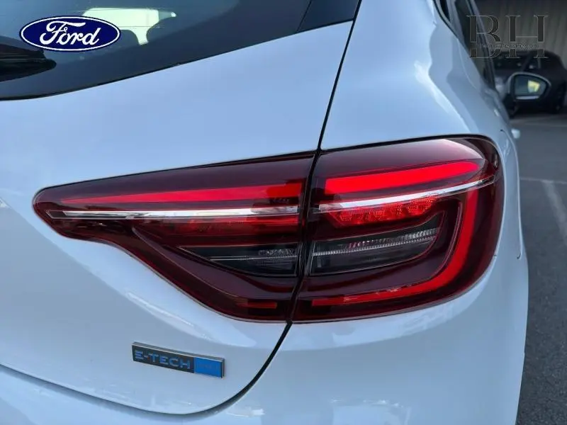 Gros plan sur le feu arrière droit blanc glacé de la Renault Clio 1.6 E-Tech 140ch avec badge E-TECH visible.