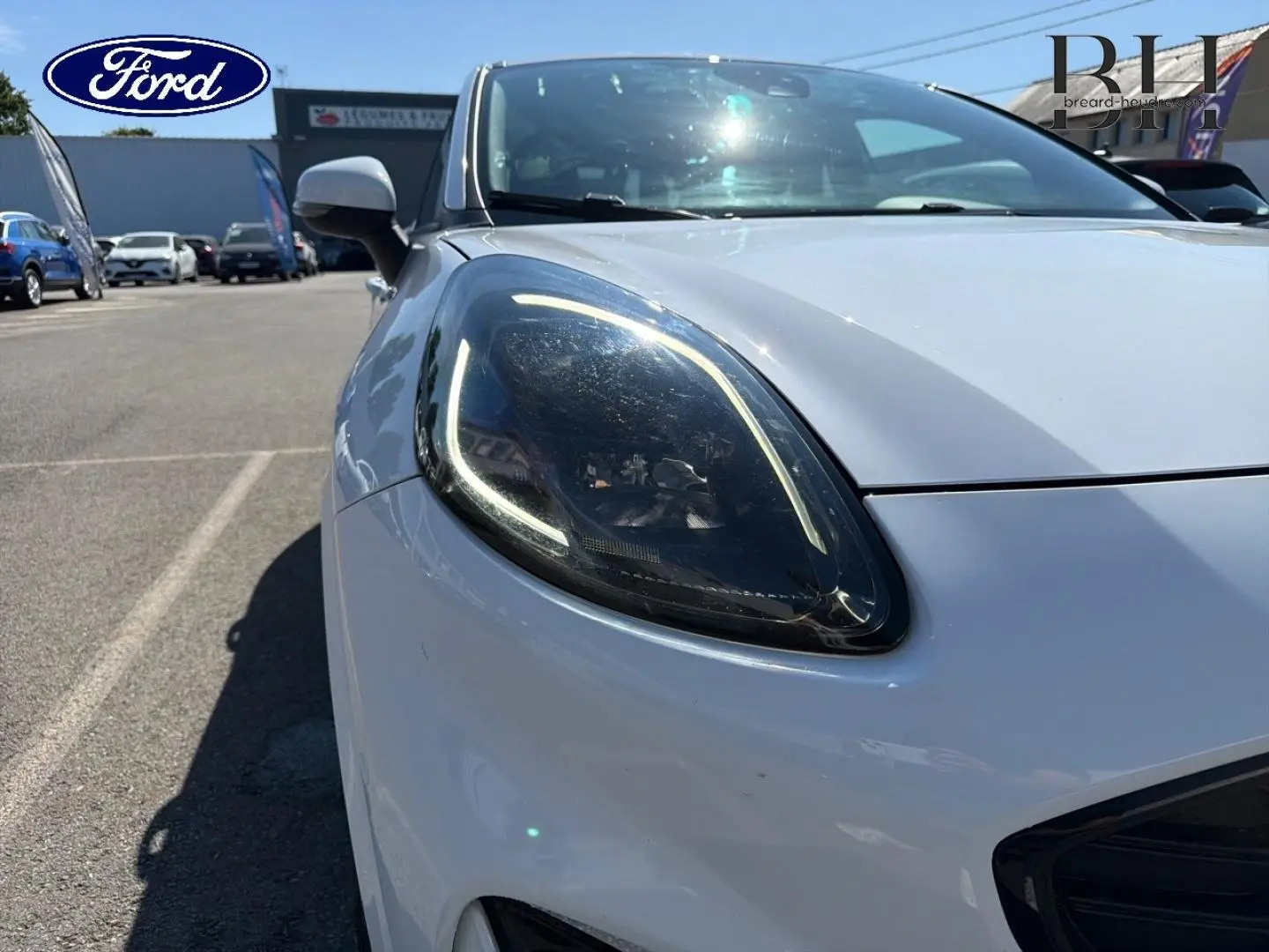 Gros plan sur le phare avant gauche du Ford Puma blanc glacier, mettant en valeur son éclairage LED distinctif.