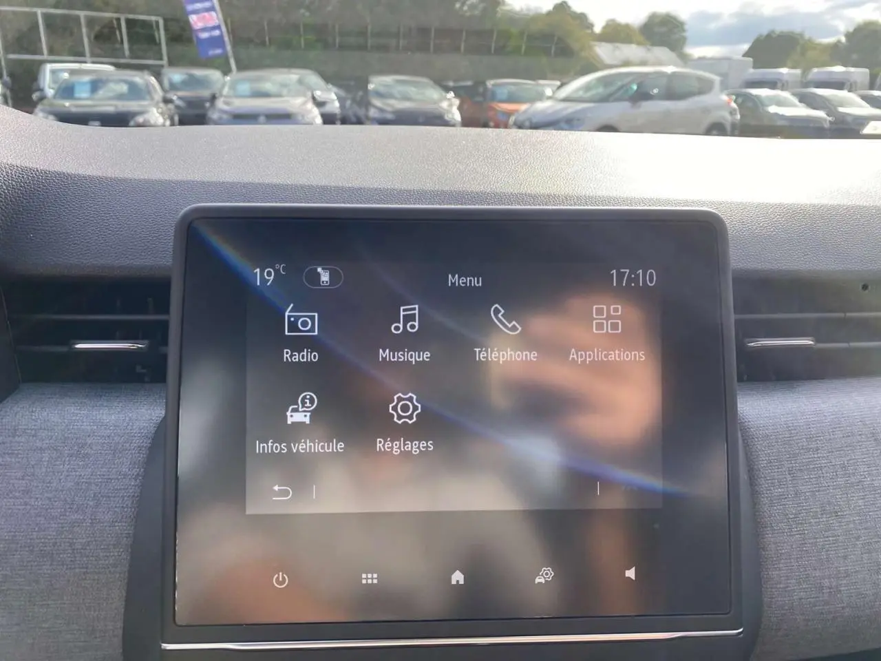 Écran tactile central de la Renault Clio noire étoilé 2025, affichant menu radio, musique et téléphone.