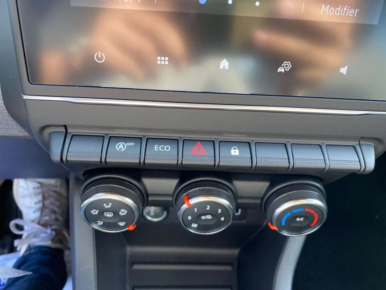 Gros plan sur la console centrale de la Renault Clio 2025 avec commandes de climatisation manuelle et boutons fonctionnels.