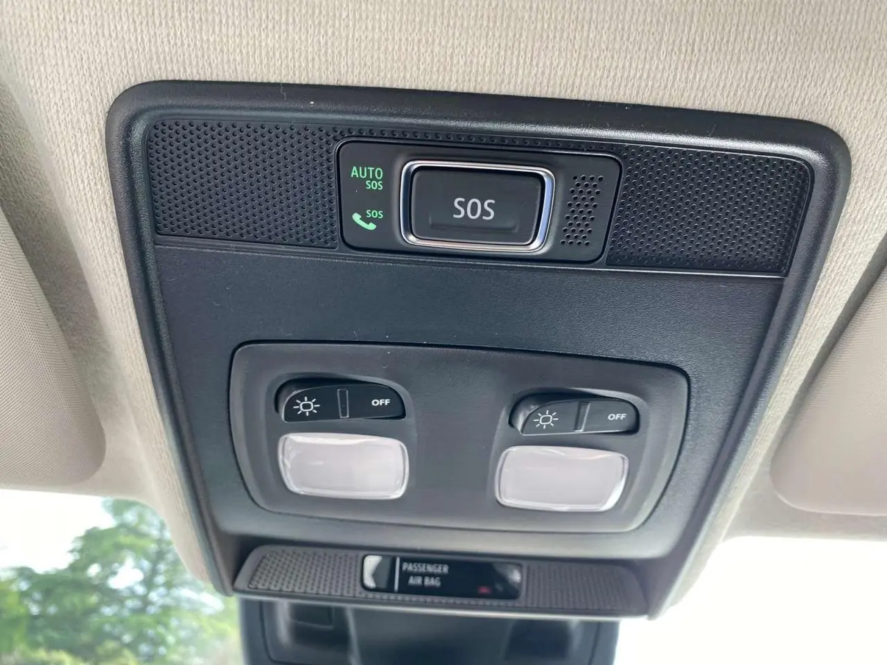 Boutons d'éclairage et alerte SOS en gros plan sur le plafond intérieur d'une Renault Clio noire étoile 2025.