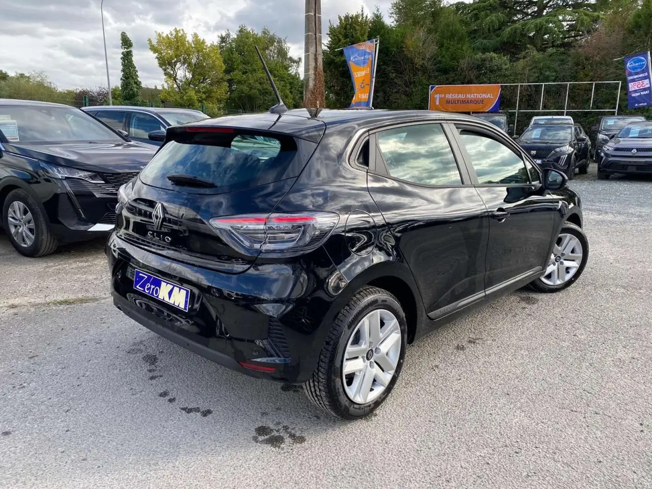 Vue 3/4 arrière droite d'une Renault Clio noire étoilé 2025 avec feux LED et jantes alliage visibles.