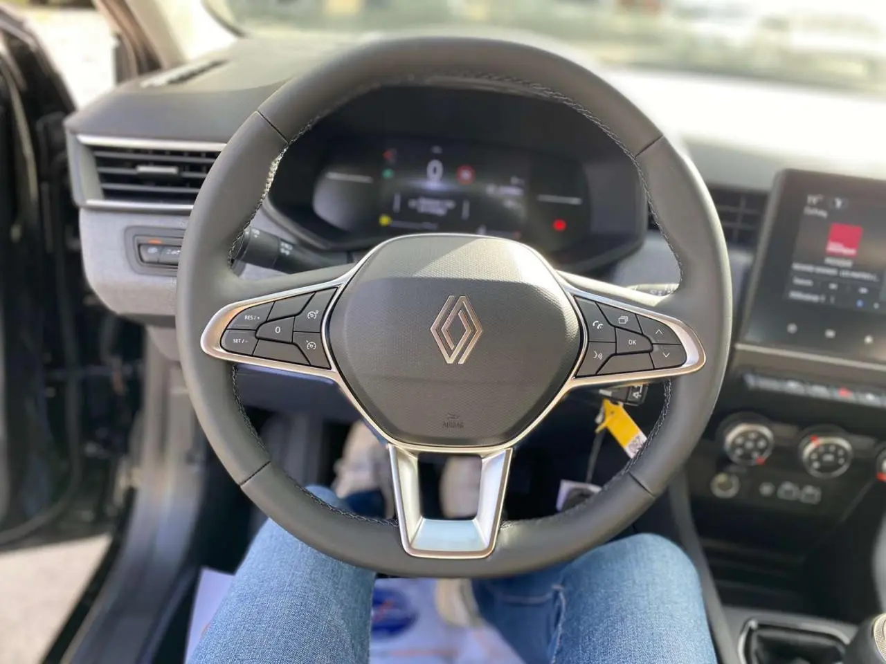 Vue centrée sur le volant cuir noir de la Renault Clio 2025 avec commandes intégrées et tableau de bord numérique.