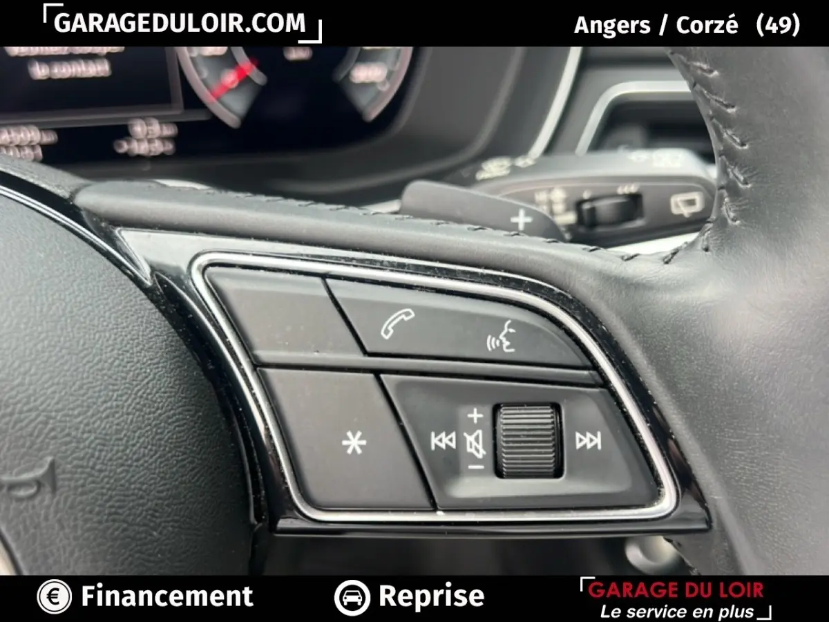 Gros plan sur les commandes au volant cuir noir de l'Audi A4 40 TFSI ultra 190 S tronic Avus, avec boutons multifonctions.