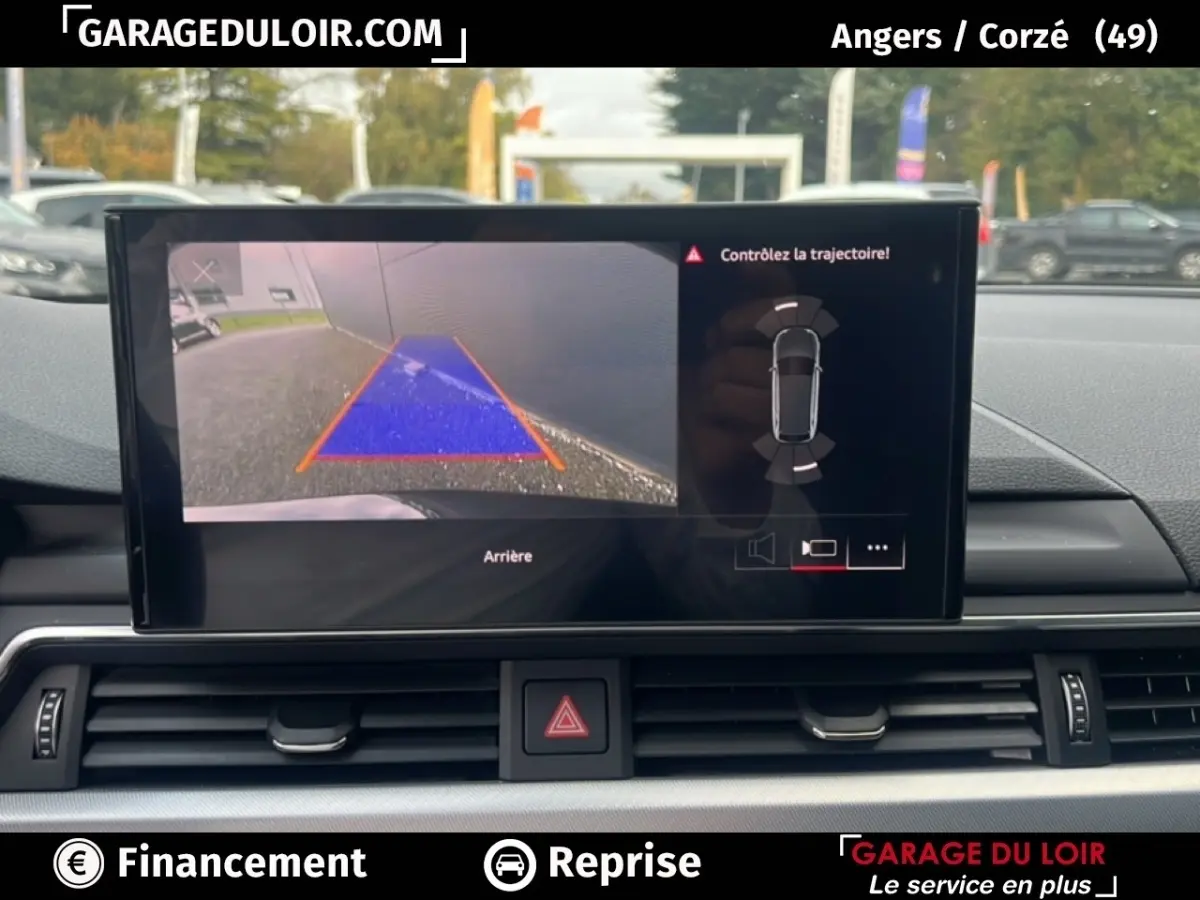 Écran tactile intérieur affichant la caméra de recul et l’aide au stationnement de l’Audi A4 noire, vue de face.