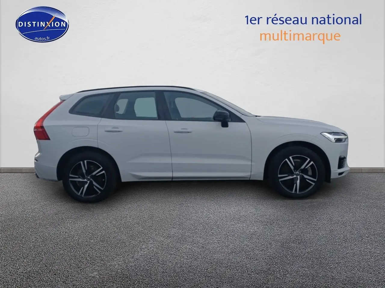 Profil côté gauche d'un Volvo XC60 blanc 2021 avec jantes alu noires et toit panoramique en verre.