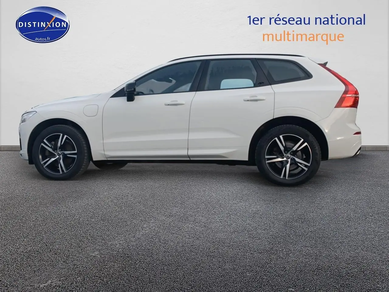 Profil droit d’un Volvo XC60 blanc 2021 avec jantes alliage noires et toit panoramique en verre visible.