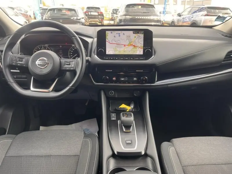 Vue intérieure frontale du tableau de bord du Nissan Qashqai 2022 avec écran tactile GPS et volant multifonction cuir.