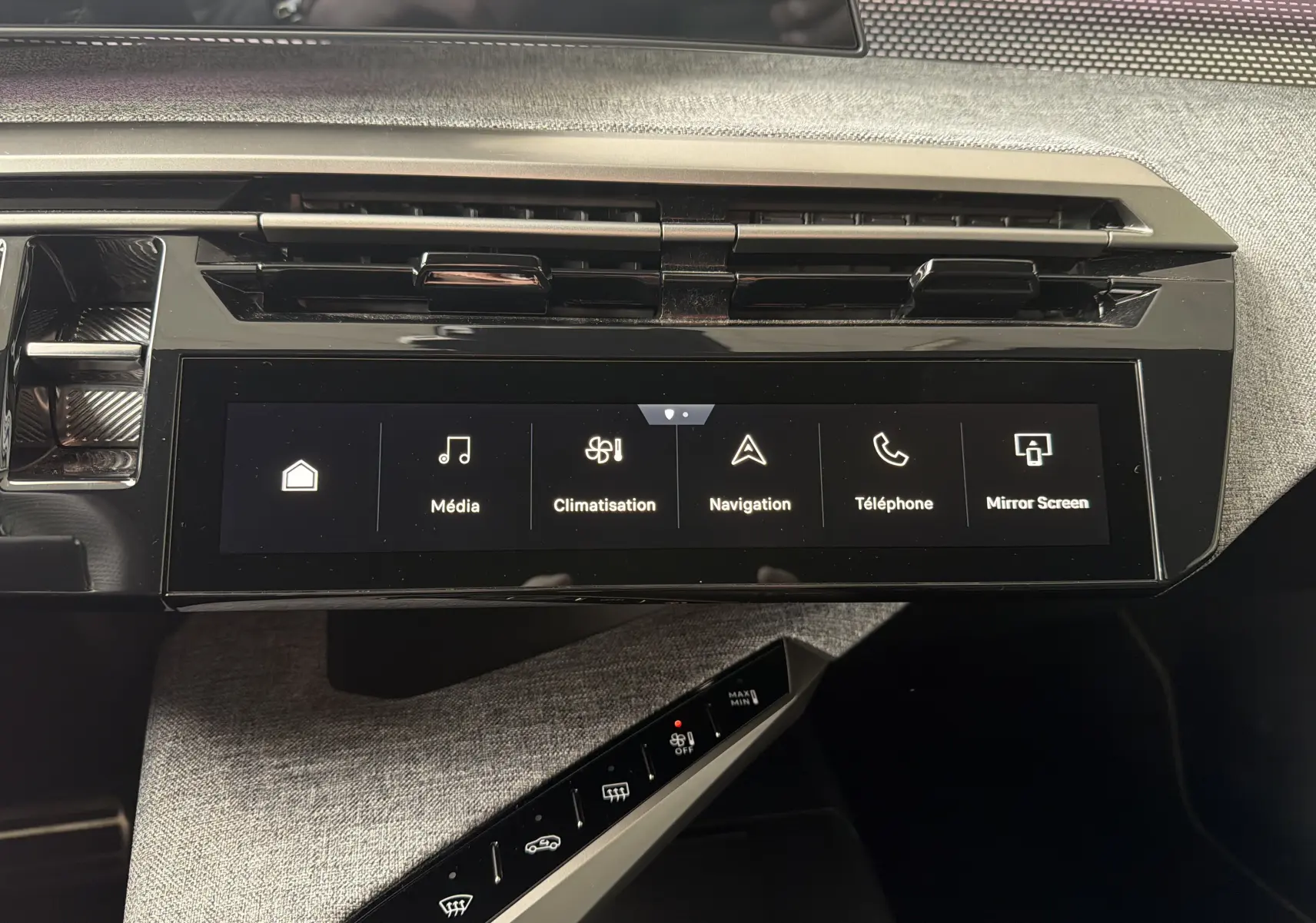 Vue rapprochée de l’écran tactile central et de la console avec commandes tactiles du Peugeot 5008 Hybrid blanc, intérieur gris.