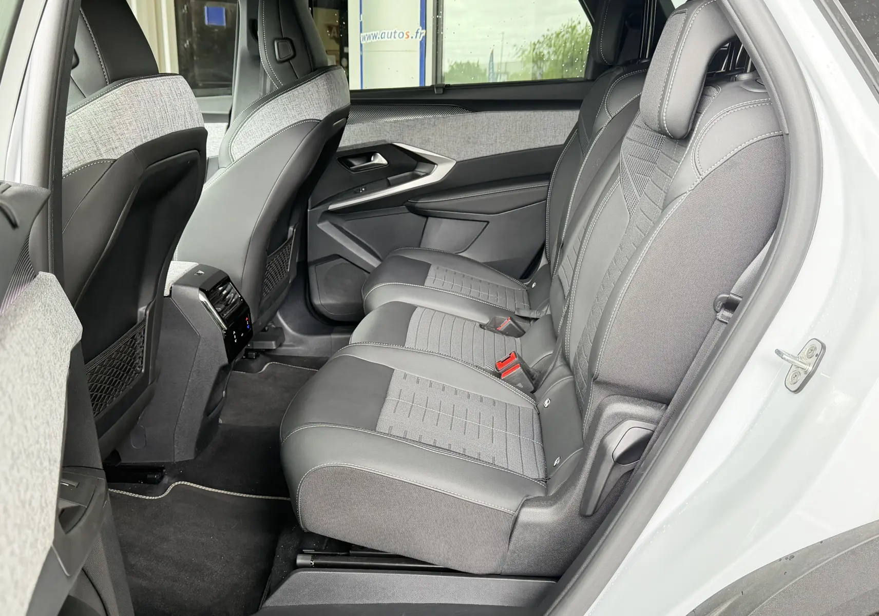Vue latérale intérieure arrière droite du Peugeot 5008 blanc, sièges tissu/tepp gris avec surpiqûres claires et console centrale.