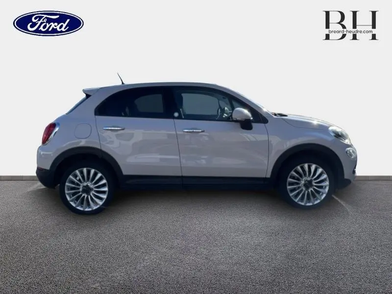 Vue latérale droite d'une FIAT 500X argentée de 2015 avec jantes alliage et poignées chromées.