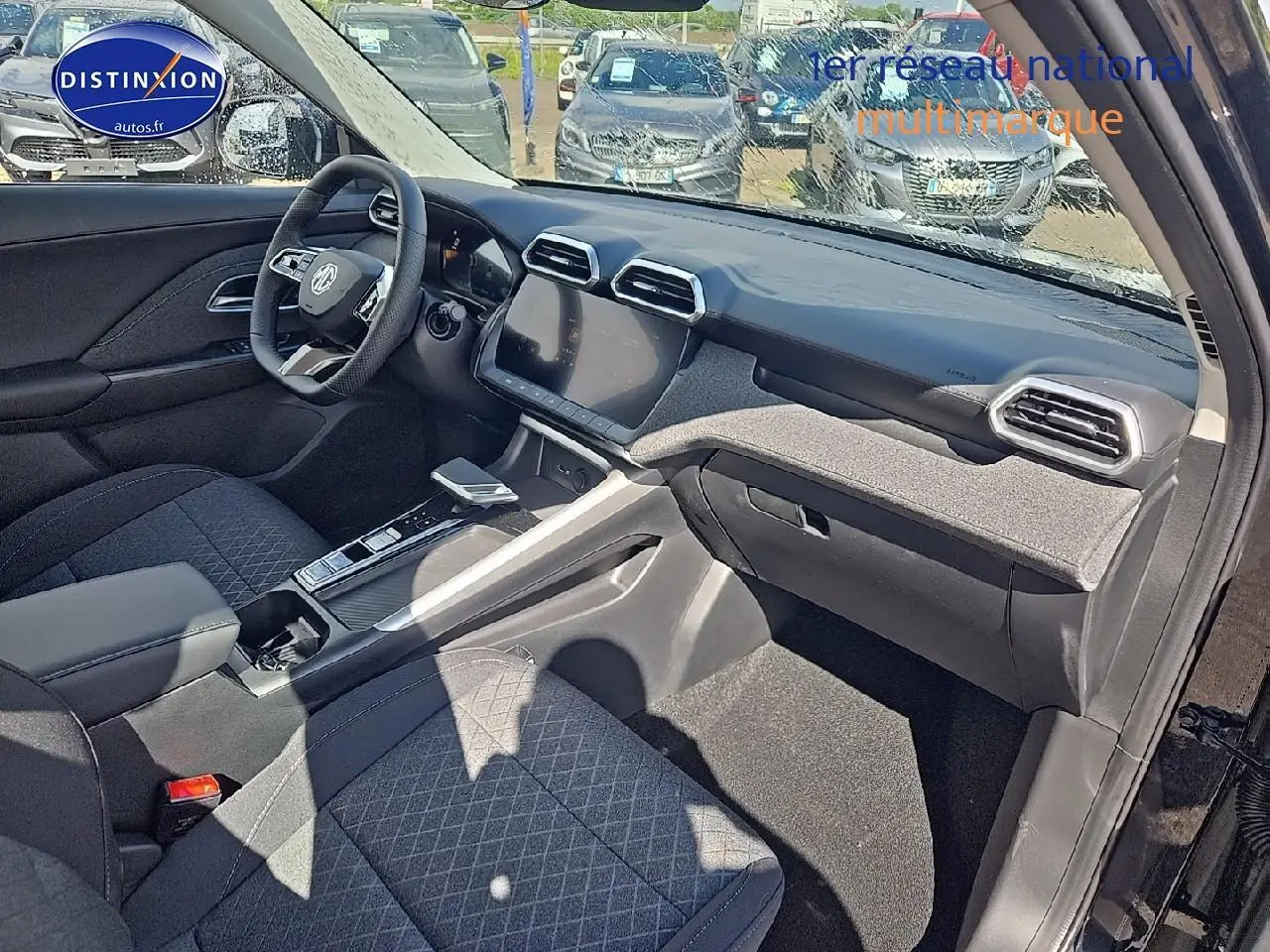 Vue intérieure côté passager du tableau de bord et console centrale du MG ZS Hybrid 197 noir avec écran tactile 10,25 pouces.