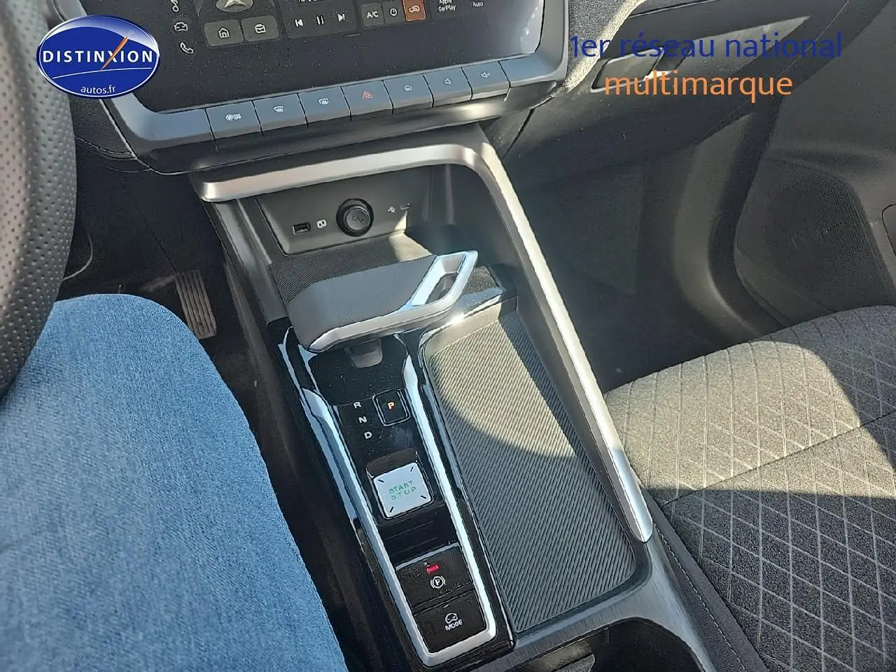 Vue intérieure centrée sur la console centrale et levier de vitesse automatique du MG ZS Hybrid noir, avec siège tissu gris.