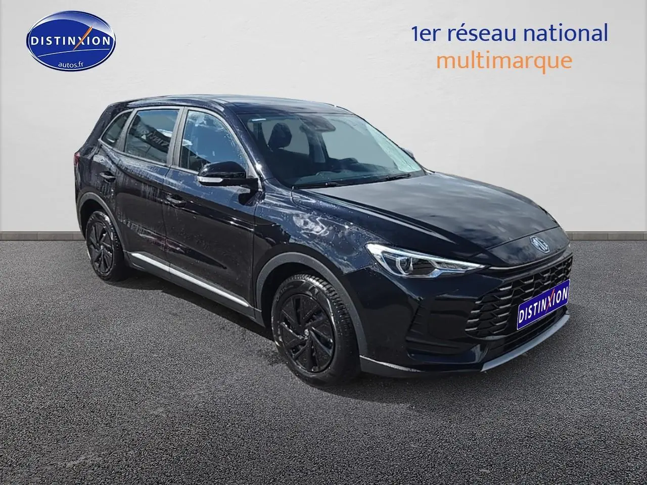 MG ZS Hybrid noir en 3/4 avant droit, avec jantes noires et calandre imposante sur fond clair.