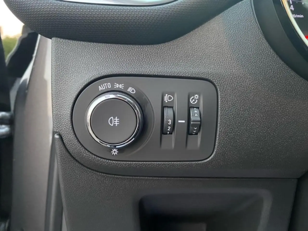 Gros plan sur les commandes d’éclairage intérieures noires de l’Opel Crossland 2022, finition X Elégance.