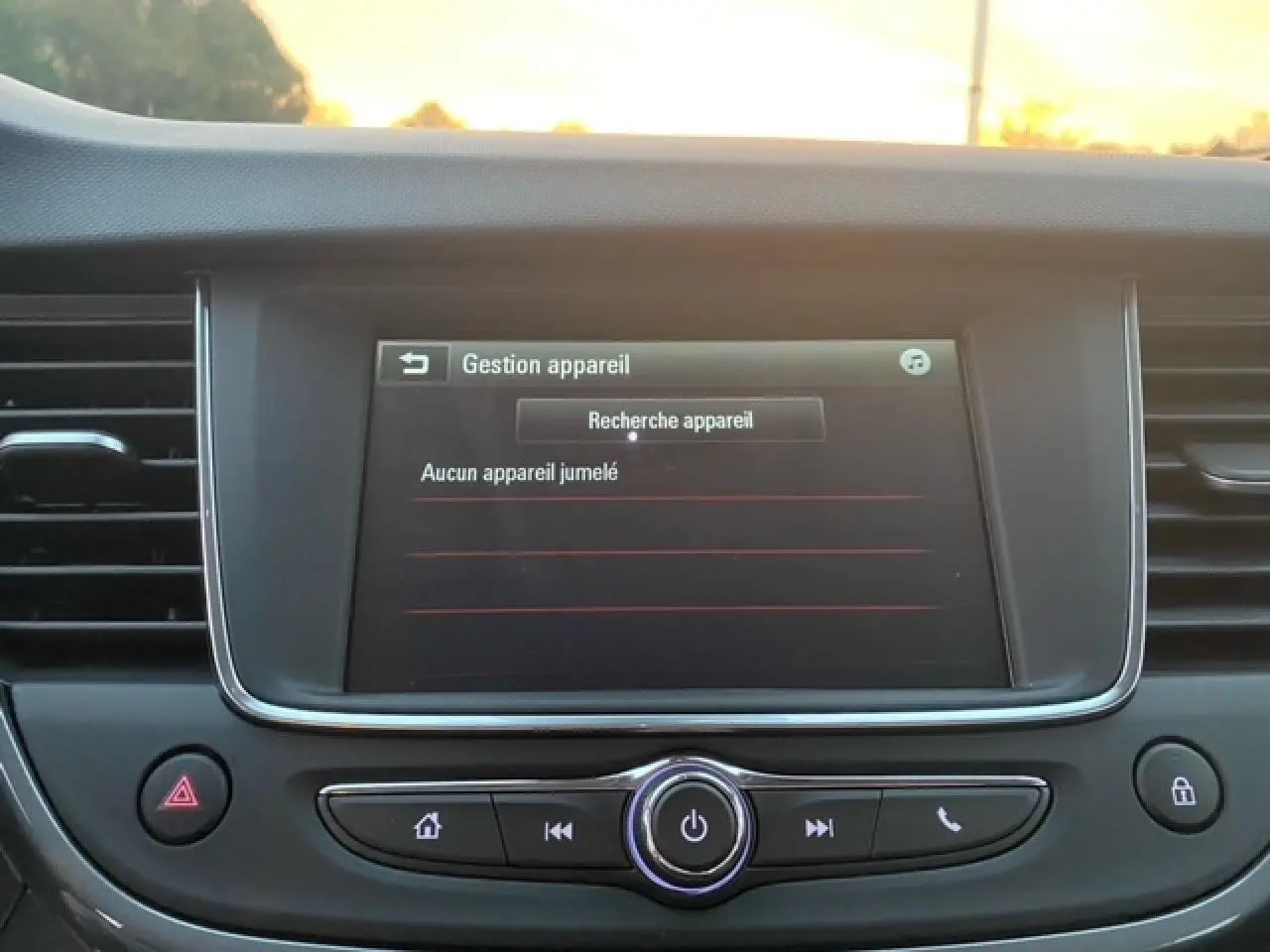 Écran tactile central de l’Opel Crossland 2022 affichant la gestion des appareils en mode recherche, entouré de commandes noires.